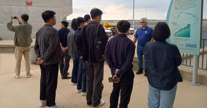 Andy Schimpf, operations manager for the St. Louis Engineer District, explains the operation of the Mel Price Lock and Dam to a group of Korean grain buyers. [Photo by David Murray]