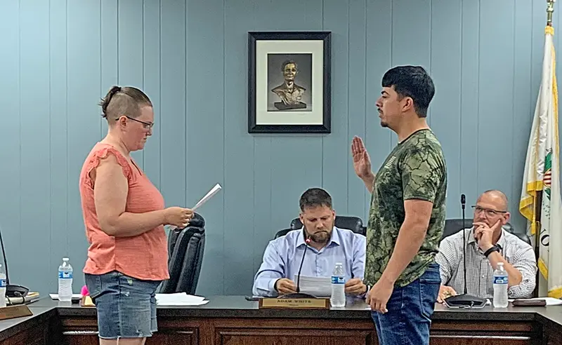City Clerk Tia Galloway administers the oath of office to Payton Lopez.