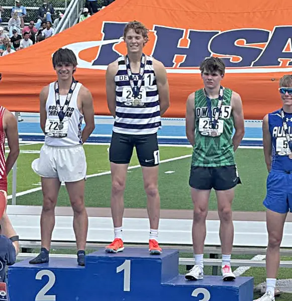 Delavan sophomore Corie Green standing center stage wearing the medal of the Illinois State Champion in the 800m race.