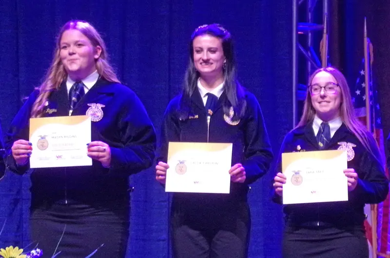 Callie Carlton (center), on stage receiving the 