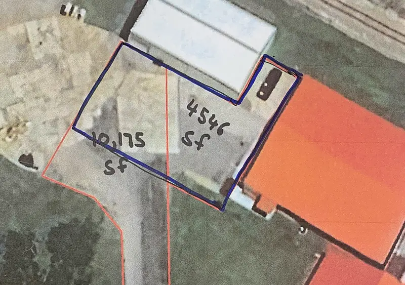 Revised project map for parking lot paving. The original layout is outlined in orange, while the updated, scaled-back version is marked in black.