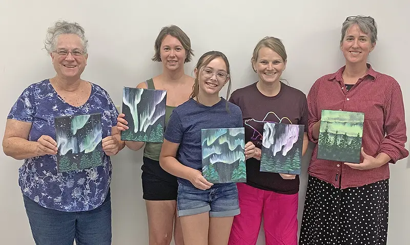 From left to right, Judy Aeschlimann, Emily Shearer, Julia Shearer, Adele Wheeler, and Sarah Flint proudly display their stunning Northern Lights creations at Ayer Library’s Paint Night on July 24. Each canvas glows with color and technique, thanks to an evening of inspiration, laughter, and a touch of makeup brush magic.