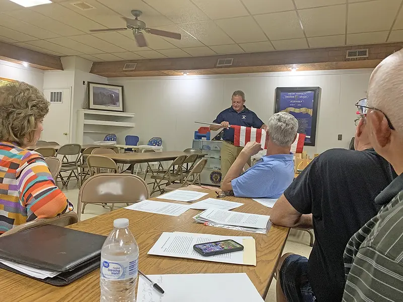 Highland Optimist Club President Terry Lammers (center) demonstrates the flag-setting equipment used in the Avenue of Flags program during a presentation to the Delavan Optimist Club. Pictured (left to right) are Liz Skinner, Lammers, Steve Skinner, Greg Dirks, and Walt Dare.
