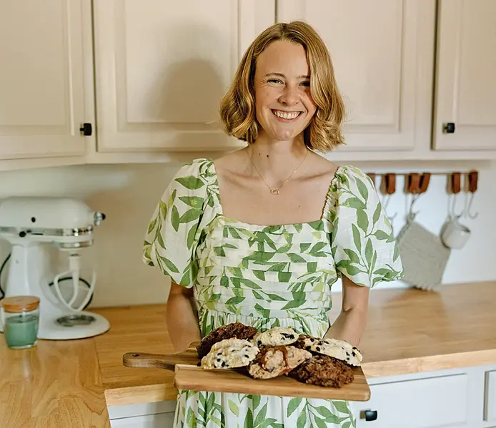 Reka Brooks beams with pride as she presents a plate piled high with fresh-baked treats from Little Piggy Bakery—each scone, cookie, and slice a warm tribute to her heritage and homemade craft.