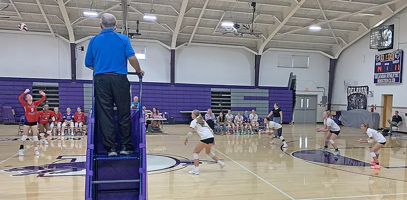 Locked in and ready for the return—Panthers Kara Lowry, Addi Fisher, Gwen Tierney, and McKinzey Ring (left to right, in white uniforms) brace for impact during a tense third set against Peoria Heights. Their focus and formation reflect the grit that carried Delavan to a 26–24 victory.
