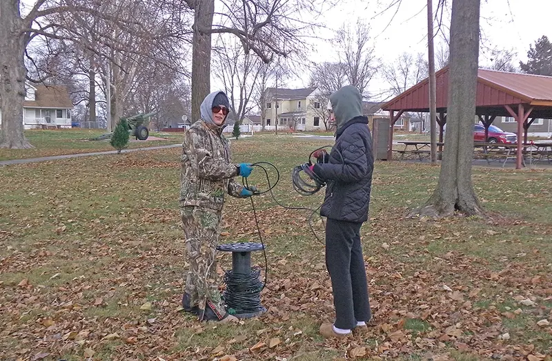 Park Board President Becky Lowry (left) and her daughter Kara Lowry (right) prepare to run electricity to the Christmas trees in Veterans Park, ensuring the holiday display will shine bright for the community.