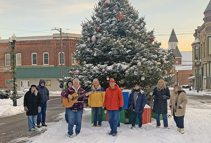 From left: Karen Valouche, Robert Valouche, Dennis Lowry, Jan Winkler, Mary Ruth Lowry, Gail Strunk, Aretha Burress, Linda Slabaugh, and Jeannie Farris — with Janice Allgood just out of view behind Gail Strunk — gathered around the Locust Street Christmas tree to share in the performance of ‘Our Hometown Christmas Tree.’