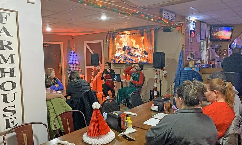 Farmhouse owners Laura and Josh Grys set the stage for Christmas Trivia Night, laying out the rules before the competition began.