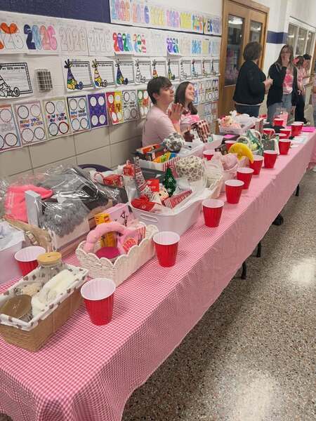Elisha Waggoner (left) and Izzy Brothwood (right) greet supporters at the bustling Pink Out raffle table, helping raise funds and awareness for metastatic breast cancer during Tuesday night’s game.