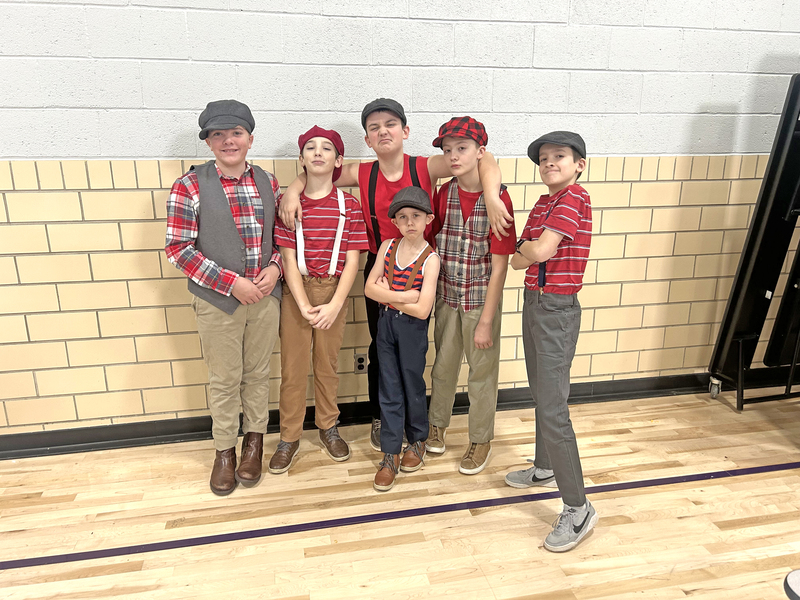 The Brooklyn newsies—Stout Williams, Karson Lowry, Elliot Knapik, Everett Tierney, Sam Zimmer, with Oliver Knapik in front—strike a pose.