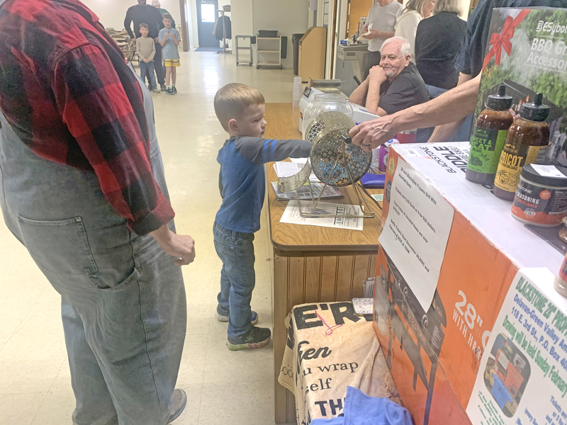 Oliver Anderson reaches in to draw the winning ticket.