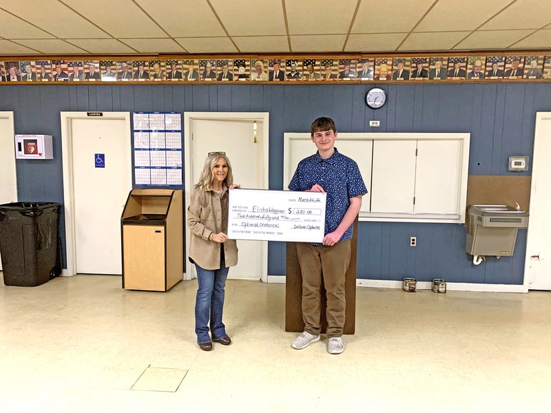 Optimist Club member Debbie Woiwode presents Elisha Waggoner with a $250 check after his first?place finish in the club’s Oratorical Contest.