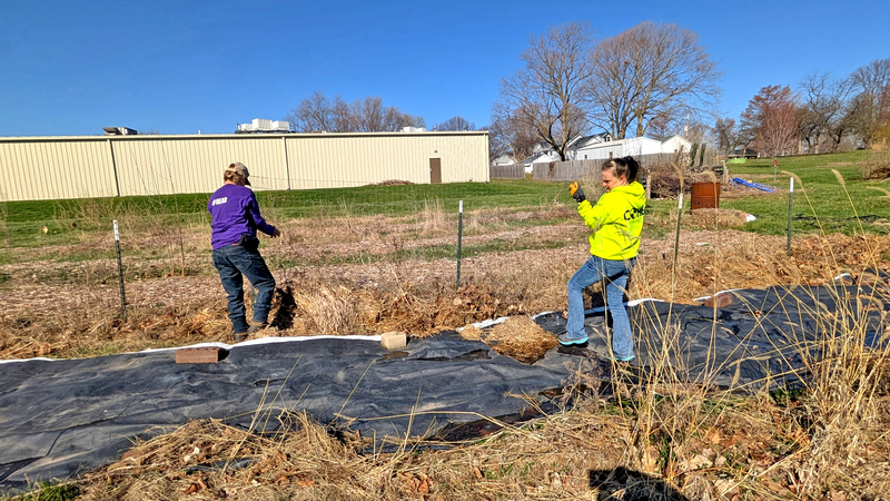 Aretha Burress and Kayla Rogers lay tarps and mulch the beds as preparations ramp up for the new growing season at Anticipation Acres.