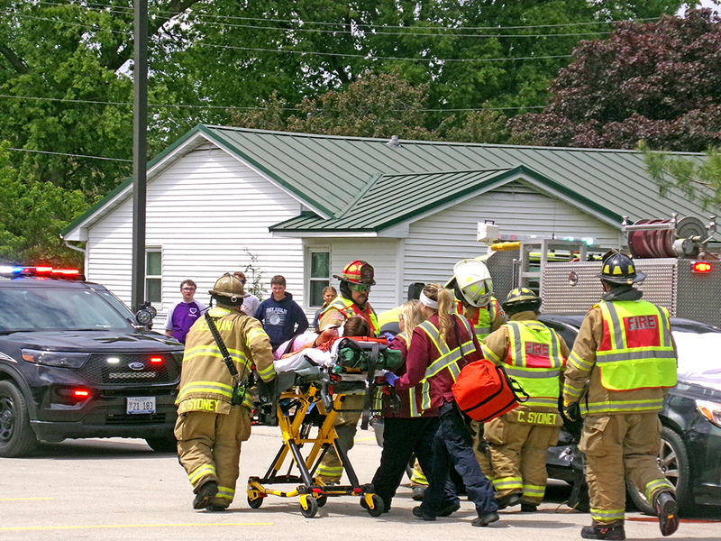 McKinzey Ring, portraying the responsible driver in the re-enactment, is rushed from the staged crash site by Delavan Fire and Ambulance personnel as first responders demonstrate the urgency of real-world emergency care.