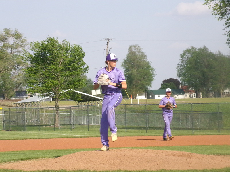 In a file photo from earlier this spring, pitcher Corie Green winds up as first baseman Lyndon Miller stands poised in the background.