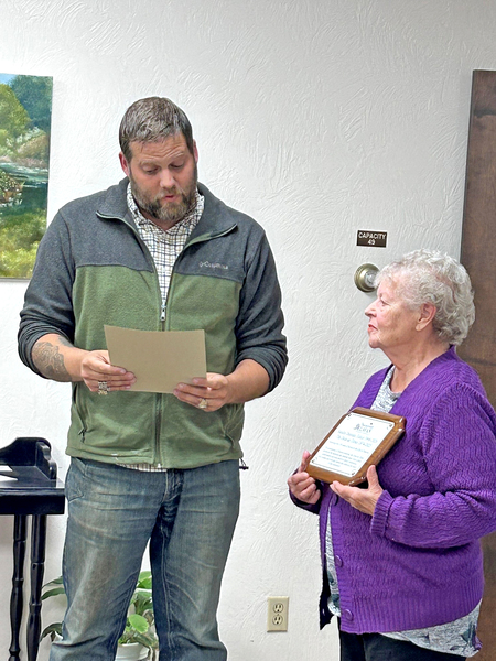 Mayor Adam White reads his proclamation after presenting Sandra Denman with a plaque honoring her decades of service to the Delavan community.