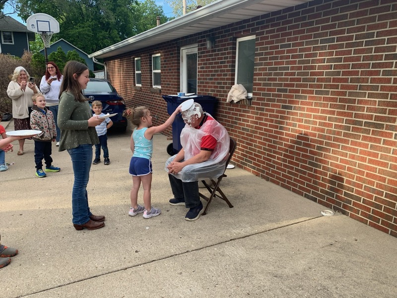 Clubber Oakley Endres gleefully adds her pie to the growing collection on Pastor Andy, sealing the kids’ hard?earned, whipped?cream?covered victory after surpassing their fundraising goal.