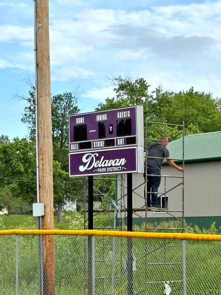 Jared Williams adds the final touches to the new Gardner Field scoreboard, completing a community-driven project made possible through volunteer dedication and local support.