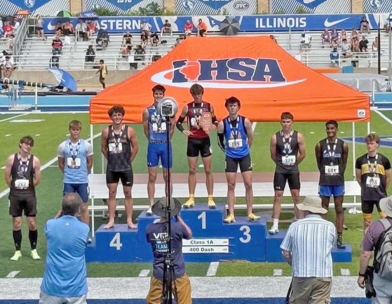 Delavan senior Nick Glisson (third from left) stands proudly on the podium after earning 4th place in the Class 1A 400m Dash for the Delavan/Illini Central Co?op.