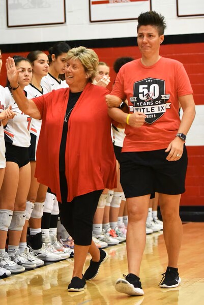 Darla Moldenhauer, left, is escorted by Bradley-Bourbonnais girls volleyball coach Leigh Reiniche, whom she once coached herself at the school, during a Title IX celebration at the school in 2022.
