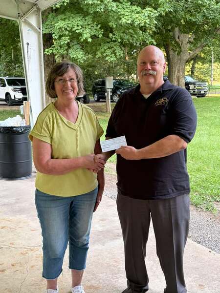 Becky Kendregan (left) of the Delavan Fall Festival Committee accepts a donation from Dean Phillips (right) of the Delavan Masonic Lodge. 